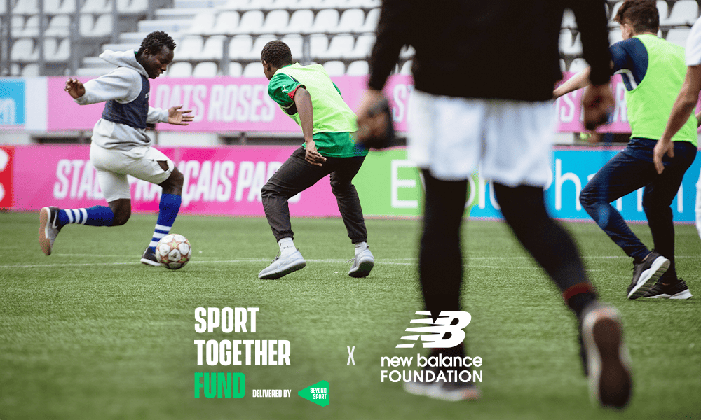 Group of players engaging in a soccer game. 'Sport Together Fund delivered by Beyond Sport' logo sits at the top of the image.